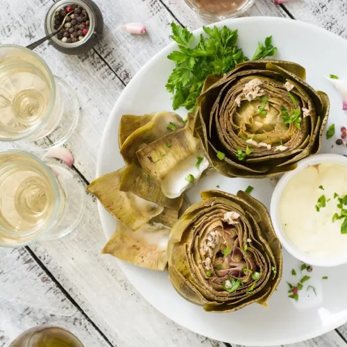 Artichauts cuits à la vapeur au Cookeo dans une assiette avec sa vinaigrette citronnée