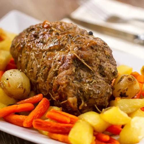 Rôti de veau servi avec des carottes et des pommes de terre