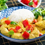 Assiette d'aiguillettes de poulet au curry servi avec du riz