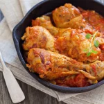 Pilons de poulet à la basquaise servis dans une assiette