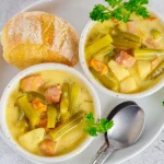 Bols de poireaux et pommes de terres à la crème servis avec une tranche de pain