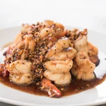Queues de langoustes sauce serives dans une assiette