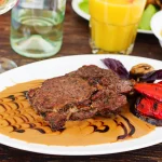 Assiette de bifteck servi avec sa sauce et des légumes
